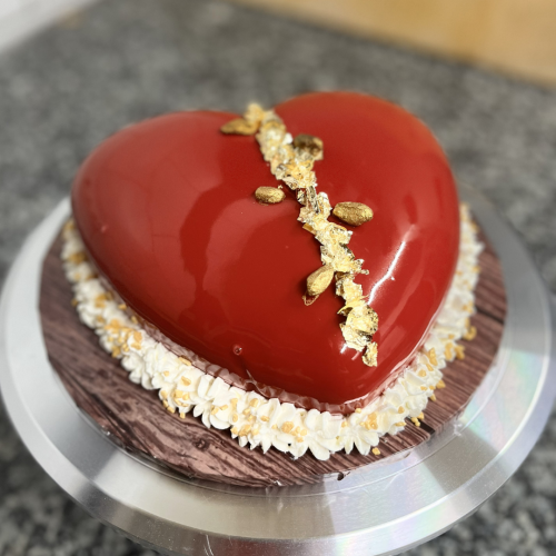 Premium-Herztorte mit Erdbeer-Joghurt und Schokolade, roter Glanzglasur und goldener Dekoration in Leipzig