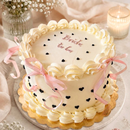 Personalisierte Bride-to-be-Torte mit Schleifen, Herzdetails und heller Creme in Leipzig